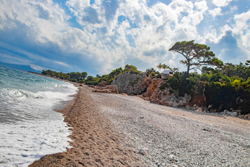 beautiful pebble beach with rocks and fir trees in Kemer Turkey in September
