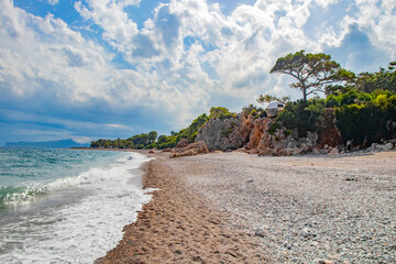 beautiful beach with rocks, pebbles and fir trees in Kemer Turkey in September