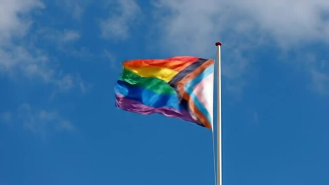 LGBTQ+ Pride Flag Waving Against a Clear Blue Sky, Pride Month