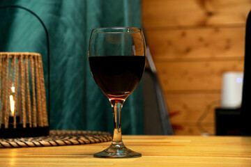 A glass of red (or white) wine placed on a table. A simple yet elegant composition evoking relaxation, fine dining, or a cozy evening atmosphere.

