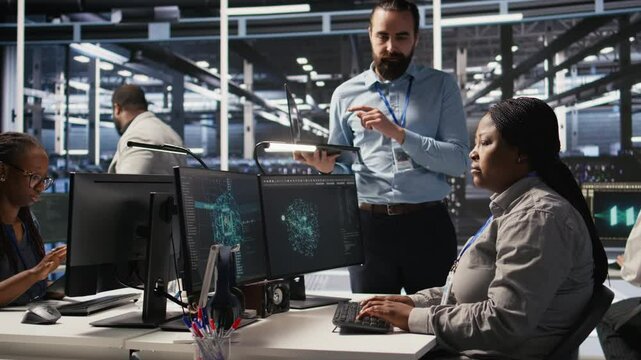 Annoyed data center employee making rude hand gesture toward colleague during workplace disagreement. Upset woman in server hub being dismissive to coworker during dispute, camera A