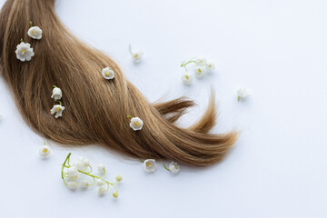 Hair with white merry bells flowers. Closeup, on a white background.