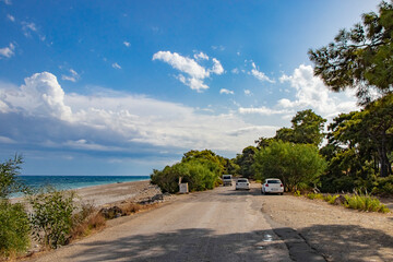 a road directly on the beach with beautiful turquoise water and beautiful trees on the roadside