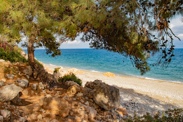 view of the beautiful pebble beach with turquoise sea from the small rock in Kemer Turkey