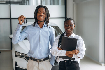 Deal has made, happy new owner. Car seller is assisting client in the automobile salon