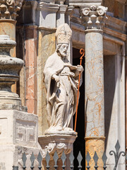 Sculpture of bishop Saint Pancratius (San Pancrazio), stands to left of entrance of Chiesa di San Pancrazio, Taormina, Sicily, Italy. Classical columns and architectural details visible in background