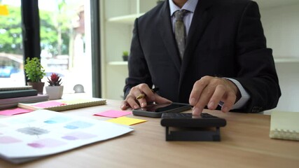 Concentration and Calculation: A professional businessman, immersed in the details, meticulously working on the calculator to arrive at financial solutions.