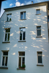 Windows of a residential building in the morning, sun reflections on the walls. Abstract