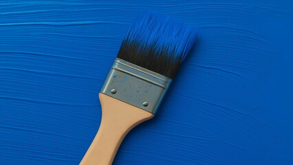 Paintbrush resting on a field of blue paint