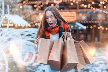 Excited young woman joyfully unpacks shopping bags during winter festival in a charming festive market