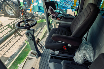 Comfortable Driver's Seat and Steering Wheel Inside the Cabin of a Combine Harvester Agriculture