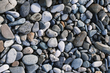 two disposable white and black coffee cardboard cup against the backdrop of the sea coast, sandy seashore, pebble beach. mock up, place for logo
