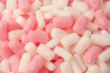 Pink and white box filler as a background. Top view.