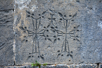 Cross on a stone. Armenian Khachkars. Sculpture of a cross on flat stones