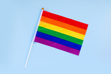 LGBT rainbow flag flat lay on light blue color background. gay marriage, human rights, june parade, lgbtq proud history month concept, coming out day. top view, place for text or logo