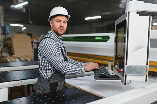 Carpenter operating cnc machine in furniture factory