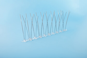Pigeon deterrent spikes with multiple steel rods mounted on clear base for property protection. Useful for commercial cleaning teams, garden centers, and urban pest services