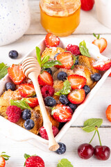 Summer fruit and berry french Toast baked Casserole. Homemade hot tasty delicious french Toast baking, breakfast cake with cream, toast bread and fresh strawberry, blueberry, raspberry and cherry