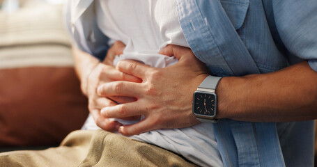Person, hands and stomach ache with gastro infection, indigestion or constipation on sofa at home....