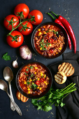 Chili con carne - traditional mexican minced meat and vegetables stew in tomato sauce. Top view with copy space.
