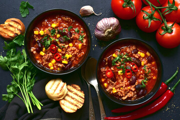 Chili con carne - traditional mexican minced meat and vegetables stew in tomato sauce. Top view with copy space.