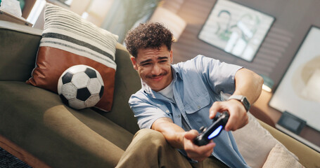 Playing, video games and man with controller, home and fun with virtual sport in living room and online sports. Apartment, gamer and person with tech for entertainment, streaming and player on couch