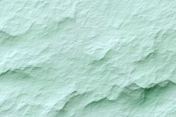 Obraz premium A close-up captures the nuanced texture of a light green surface, revealing subtle ridges and shadows in an abstract, organic design.