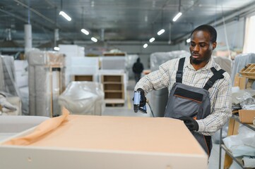 African american Carpenter upholstering furniture in busy workshop
