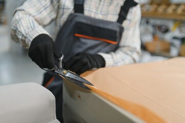 Skilled worker cutting fabric in furniture production