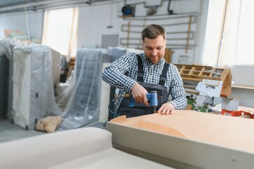 Carpenter using pneumatic stapler in furniture factory