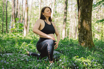 Pregnant woman doing fitness outdoors.