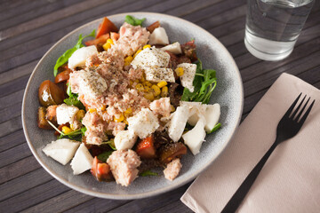 Plate of salad with tuna, corn, tomatoes and arugula