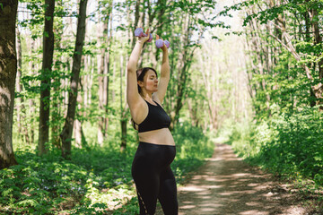 Pregnant woman doing fitness outdoors.