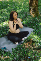 Pregnant woman doing fitness outdoors.