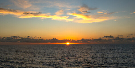 Stunning sunset over the ocean. Warm colors paint the sky as the sun dips below the horizon, creating a peaceful scene