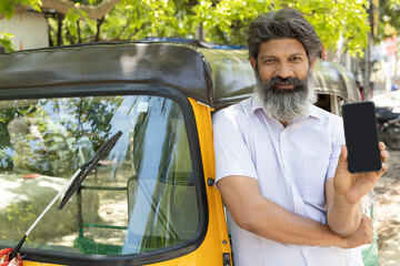 Indian auto rickshaw driver man showing smartphone.