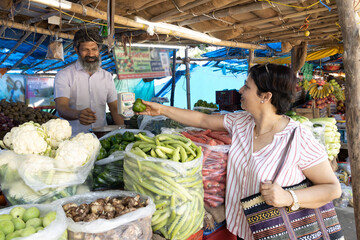 Indian woman purchasing vegetables on grocery market