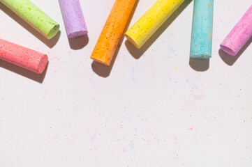 Multicolored bright crayons for drawing on light gray background flat lay top view. Children's...