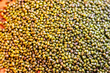 Mung bean in wood spoon Close-up view of dried mung beans texture background