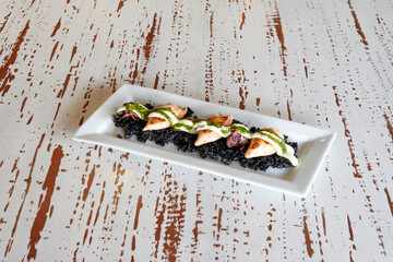A plate of food with a green sauce on it. The plate is white and has a black border
