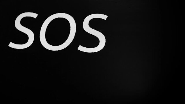 International distress signal. Black screen with flashing stripe and three letters SOS. Morse code transmits SOS as three dots, three dashes, three dots. SOS symbol on black monitor display