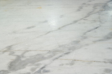A marble floor with a white streak. The marble is shiny and has a light color. The floor is clean and has no visible dirt or stains