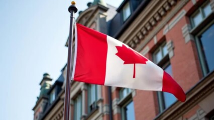 Canadian flag proudly displayed on the facade of a historic building, symbolizing national heritage and patriotism. Ideal for travel, cultural, and educational materials focusing on Canadian identity.