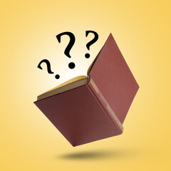 Question marks above open book in air against golden background