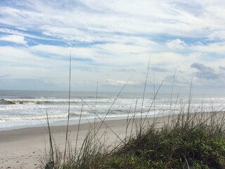 Early morning Cocoa Beach Florida sandy beach with cloudy blue sky 