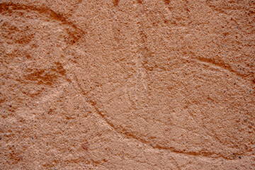 Detail of an old textured adobe wall with various reliefs photographed with natural light from a historic or rural structure in Portugal.