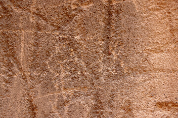 Detail of an old textured adobe wall with various reliefs photographed with natural light from a historic or rural structure in Portugal.