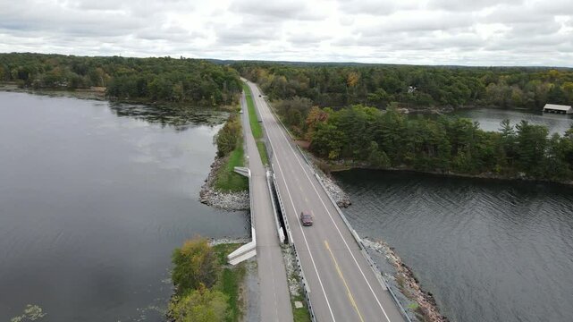 Drone view of highway spanning the water of Landon Bay Centre surrounded by forests on overcast day