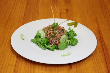 A plate of food with a meat dish and a salad. The salad has cucumbers and celery