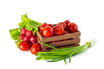 Tomatoes, radishes, green onions and lettuce in a wooden box. Isolated on white background.
